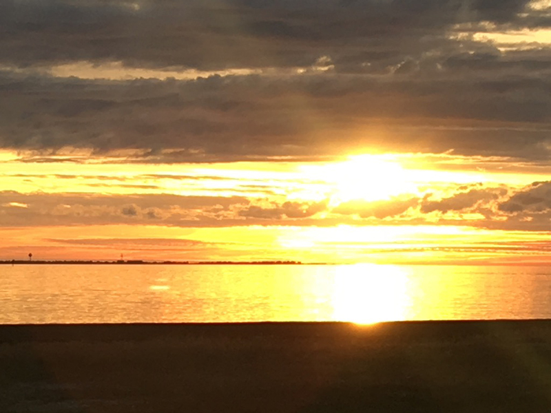Bright, brilliant, golden sunset shining off of the water. Located at the Outer Banks, North Carolina.